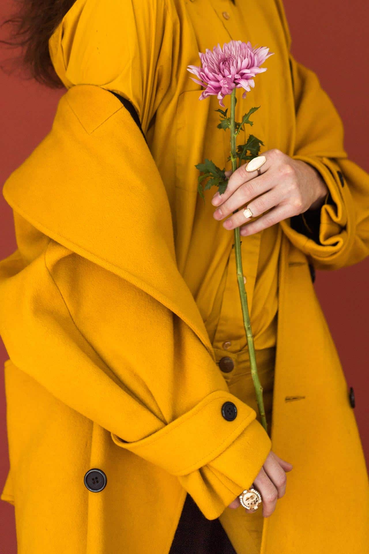 Manteau jaune élégant tenu avec une fleur – contact THE CARE