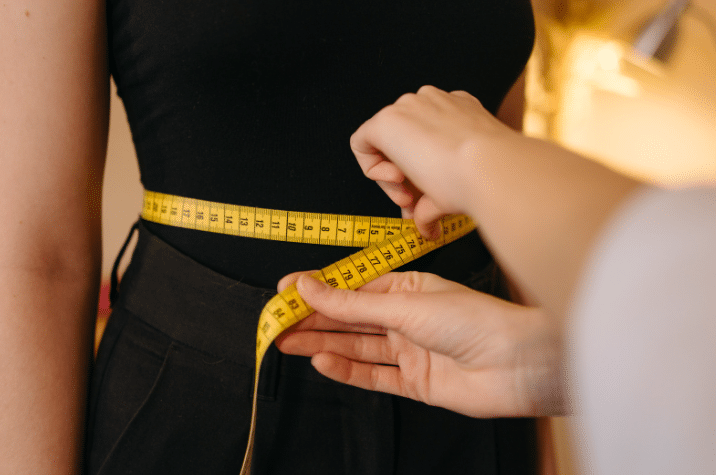Prise de mesure à la taille avec un mètre ruban – contact THE CARE