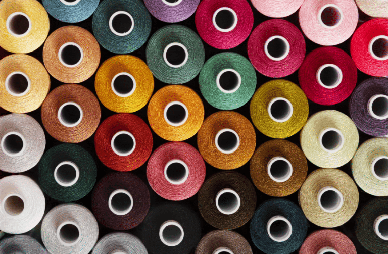Fils de couture colorés dans l’atelier THE CARE